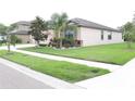 Well-maintained lawn and landscaping surround the home on a corner lot at 11617 Brighton Knoll Loop, Riverview, FL 33579
