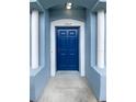 Inviting front entry with covered porch and stylish blue front door featuring white columns at 1237 Blenheim Ct, Wesley Chapel, FL 33543