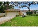 Inviting single-Gathering home with a well-manicured lawn, quaint bench, and attached garage at 13878 Oak Forest N Blvd, Seminole, FL 33776