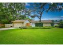 Quaint single-Gathering home with lush, green landscaping and mature trees providing ample shade at 13878 Oak Forest N Blvd, Seminole, FL 33776