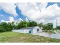 Home with a one-car garage and tidy landscaping, all enclosed by a white privacy fence at 15100 Avalon Ave, Clearwater, FL 33760