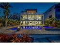 Outdoor pool area with a fire pit, a jacuzzi, and outdoor seating for entertaining at night at 15805 Redington Dr, Redington Beach, FL 33708