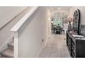 Inviting hallway leading to the dining room, showcasing tile flooring and staircase at 17012 Oval Rum Dr, Wimauma, FL 33598