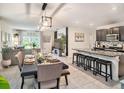 Open-concept kitchen featuring modern appliances, granite countertops, and a breakfast bar at 17012 Oval Rum Dr, Wimauma, FL 33598