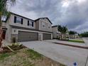 A beautiful street view of townhomes with a two-car garage and well-manicured lawns on a cloudy day at 23300 Willow Glen Way, Lutz, FL 33549