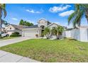 Well-maintained single-story home with a two-car garage, lush lawn, and fenced yard at 2641 Big Pine Dr, Holiday, FL 34691