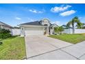 Single-story home with a manicured lawn, two-car garage, and fenced yard offering privacy at 2641 Big Pine Dr, Holiday, FL 34691