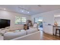 Bright living room with wood flooring, a modern sofa, natural light, and sliding door access to outdoor space at 2870 Rampart Cir, Clearwater, FL 33761