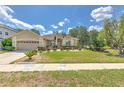Single-story home featuring a well-maintained lawn, manicured bushes, and a convenient two-car garage at 3350 Stonebridge Trl, Valrico, FL 33596