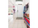 Bright foyer with tile flooring, coat rack and bench, offering a welcoming entrance to the home at 34447 Blue Ash Ct, Wesley Chapel, FL 33545