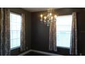 Elegant dining room featuring a chandelier and natural light from two windows at 3914 Roswell Pl, Land O Lakes, FL 34639