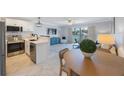 Open-concept living room features sliding glass door to balcony and updated kitchen at 4103 Gulf Blvd # 107, St Pete Beach, FL 33706