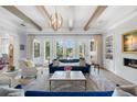 Bright living room boasts a fireplace, beamed ceiling, and French doors overlooking the backyard at 419 S Shore Crest Dr, Tampa, FL 33609