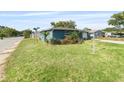 Corner lot showcasing a blue home with fresh landscaping and a green, lush lawn at 4238 Glissade Dr, New Port Richey, FL 34652