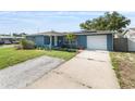 Inviting exterior of a blue home with a concrete driveway and manicured front yard at 4238 Glissade Dr, New Port Richey, FL 34652