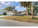 Inviting single-Gathering home with a well-maintained lawn, mature trees, and an attached garage at 504 Casas Bonitas Dr, Nokomis, FL 34275