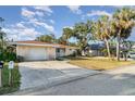 Attractive single-story home with a driveway, a front yard, and mature palm trees at 504 Casas Bonitas Dr, Nokomis, FL 34275
