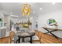Elegant dining area featuring a stylish chandelier and a glimpse of the modern kitchen at 5707 N Branch Ave, Tampa, FL 33604