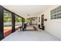 Covered front porch with black accent columns, chairs and a stylish rug at 708 53Rd N Ave, St Petersburg, FL 33703