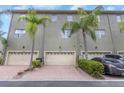 Exterior view of townhomes showcasing garages, manicured landscaping and private driveway parking at 7130 102Nd Ln, Seminole, FL 33772