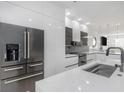 Modern kitchen featuring sleek white cabinets, stainless steel appliances, and a large center island at 7130 102Nd Ln, Seminole, FL 33772