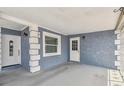 View of covered and gated entrance with white trim and classic wall lamps at 8006 Tanglewood Ln, Tampa, FL 33615
