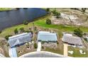 Aerial view of single-story home with pond, manicured green spaces and golf course in a well-maintained neighborhood at 904 Desert Hills Dr, Sun City Center, FL 33573