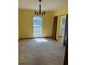 Well-lit dining room featuring a classic chandelier and a large window for natural light at 531 Carriage Hills Dr, Temple Terrace, FL 33617