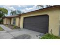 A tan single-story home featuring a large two-car garage with brown garage door at 531 Carriage Hills Dr, Temple Terrace, FL 33617