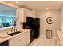 Well-lit kitchen featuring stainless steel appliances, white cabinets, and lovely tile floors at 100 Bluff View Dr # 105C, Belleair Bluffs, FL 33770