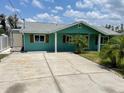 Charming single-story home with large concrete driveway, neutral exterior, and decorative shutters at 10922 Park Dr, Riverview, FL 33569