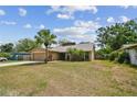 Charming single-Gathering home featuring a front yard, mature palm tree, and attached two-car garage at 11315 N Armenia Ave, Tampa, FL 33612
