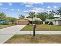 Charming single-Gathering home featuring a front yard, mature palm tree, and attached two-car garage at 11315 N Armenia Ave, Tampa, FL 33612