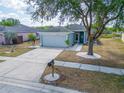 Lovely home with a well-manicured lawn, a mature tree, and a long driveway at 12119 Buffington Ln, Riverview, FL 33579