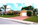 Charming single-story home featuring lush landscaping, a driveway, and a one-car garage at 12407 Partridge Hill Row, Hudson, FL 34667