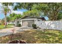 This property features an attached two car garage, a manicured lawn, and a white fence at 1332 Marjohn Ave, Clearwater, FL 33756