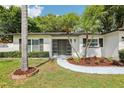 Well maintained property showcasing mature landscaping and a modern front door at 1332 Marjohn Ave, Clearwater, FL 33756