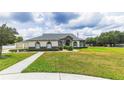Charming single-story home featuring manicured lawn and mature landscaping at 13338 Jaudon Ranch Rd, Dover, FL 33527