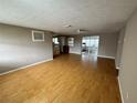 Spacious living room featuring wood laminate floors, neutral walls, and sliding glass doors to a sunroom at 1542 Derrick St, Holiday, FL 34690