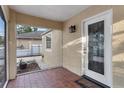Screened front porch with red tile flooring, leading to the beautiful glass front door at 2916 W Crest Ave, Tampa, FL 33614