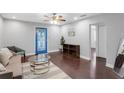 Bright living room featuring hardwood floors, stylish furniture, ceiling fan, and a unique blue door at 2916 W Crest Ave, Tampa, FL 33614