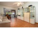 Bright living room features a large glass display case and sliding glass doors to a lanai at 3010 Beecher E Dr # A, Palm Harbor, FL 34683