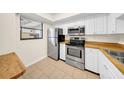 Efficient kitchen featuring stainless steel appliances, white cabinets, and tile flooring at 3038 Eastland Blvd # F102, Clearwater, FL 33761