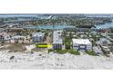 Aerial view of beachfront building, showcasing its proximity to the water and nearby bridge and cityscape at 3200 Gulf Blvd # 202, St Pete Beach, FL 33706