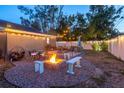 Outdoor living space with a firepit, comfortable seating, and string lights for ambiance in the fenced in backyard at 3245 Freemont S Ter, St Petersburg, FL 33712