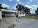 Single-story home featuring a front yard, a carport with a motorcycle, and classic detailing at 37913 Wicklow Ave, Zephyrhills, FL 33541