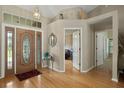 Elegant foyer with hardwood floors, a decorative light fixture, and a beautiful stained-glass front door at 4311 W Beach Park Dr, Tampa, FL 33609