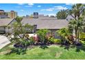 Well-maintained home with lush landscaping, including palm trees and colorful plants at 4694 Huron Rd, St Petersburg, FL 33708