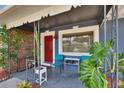 Cozy front porch with seating, plants, and a vibrant red door at 6409 N 23Rd St, Tampa, FL 33610