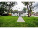 Beautifully landscaped home with mature trees and a lush lawn at 6504 N 13Th St, Tampa, FL 33604